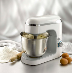 dough into kneading machine on restaurant counter