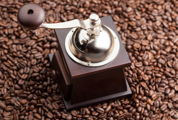 manual coffee grinder on a background of coffee beans