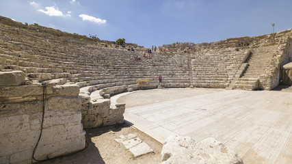 Some tourists visit the ruins of the ancient Greek theater of Segesta in Sicily, Italy.