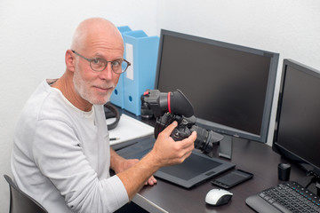 photographer with camera at office with computer
