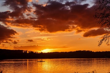 Obraz premium Ruderer bei Sonnenuntergang am See
