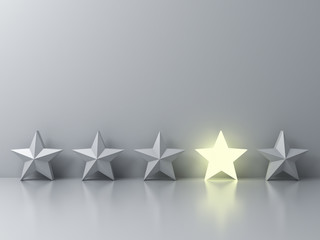 Stand out from the crowd and different creative idea concepts , One glowing star standing among other dim stars on grey background with reflections and shadows . 3D rendering.