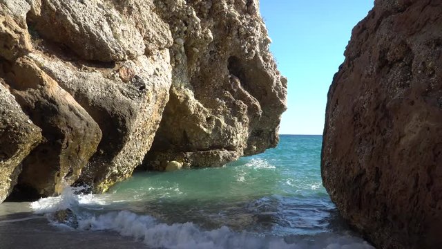 Waves between the rocks in Nerja, Malaga province; Andalusia, Spain.