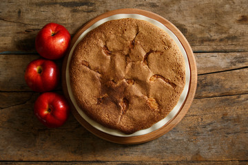 Apple pie with apples on wood background. Top view image of homemade bakery background