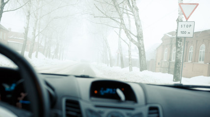 Fototapeta premium Bad weather driving with low visibility in winter. Thick fog on the road