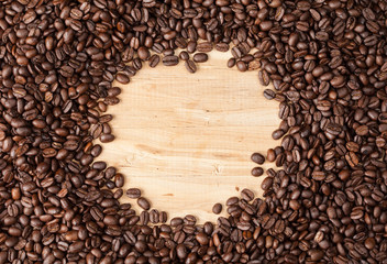 Circle frame of coffee beans on wooden table