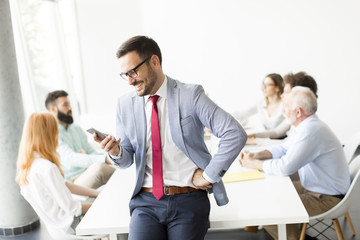 Business people discussing a strategy and working together in office while businassman using mobile phone