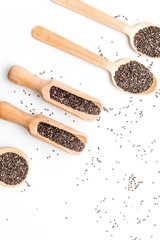 Superfood chia seeds in a wooden spoon and scoop on white background top view copyspace