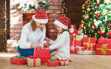 Fototapeta na wymiar christmas morning. family mother and daughter unpack, open gift