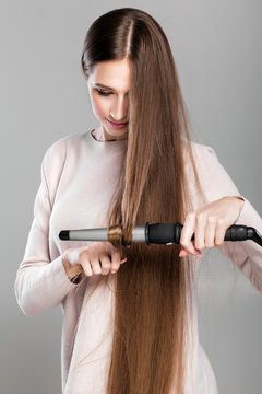 Woman Using Curling Iron.