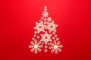 Christmas tree made of snowflakes on a red background