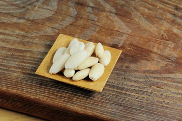 Fototapeta na wymiar Blanched almonds on wooden background.