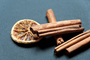 Dry slices of citrus on the background of black slate, cinnamon and anise