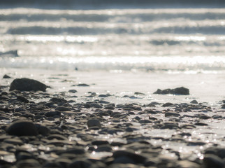 Small stones in a riverbed with bohek of flowing water