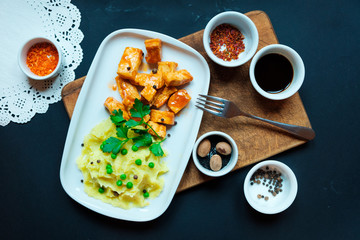 Home fried tofu cheese potatoes with green peas. close up