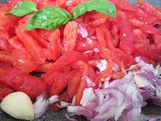 Cooking homemade tomato sauce using fresh summer tomatoes, onion, garlic and basil. Italian recipe