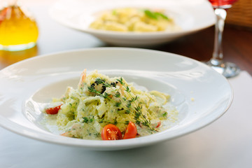 Italian food - fettuccine pasta with spinach and seafood.