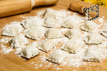Ravioli caseros sobre tabla de cocina d madera rústica. Vista de frente y de cerca