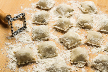 Ravioli casero sobre tabla de cocina de madera rústica. Vista superior