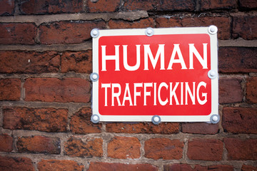 Obraz premium Hand writing text caption inspiration showing Human Trafficking concept meaning Slavery Crime Prevention written on old announcement road sign with background and copy space