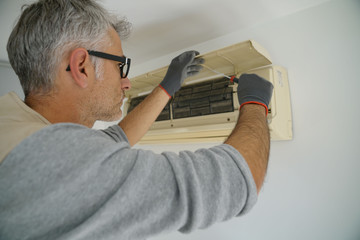 Repairman fixing air conditioner unit