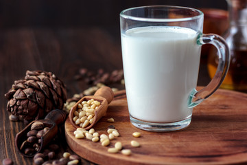 Glass filled by cedar or pine milk with nuts.