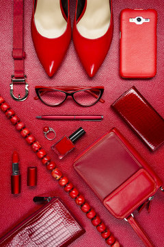 Red woman accessories, jewelry, clothing, gadget, cosmetic and other objects on leather background, fashion industry, modern female concept 