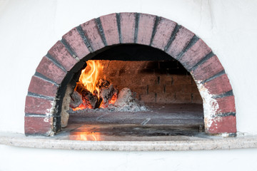 Traditional oven for cooking and baking pizza. Burning fire in the oven.