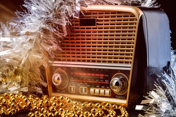 radio receiver in retro style with christmas decorations and light beams on black background