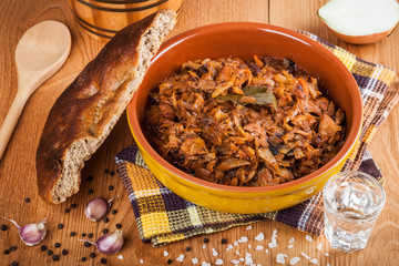 Traditional Polish bigos and fresh homemade bread closeup