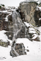 Fototapeta na wymiar Waterfall in mountains at winter