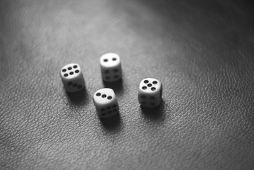 Plastic Dice on a leather surface black and white