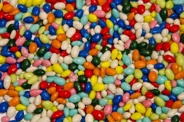 Fototapeta na wymiar Many small, multi-colored sweets are scattered as a background.