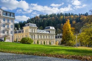 Obraz premium Spa architecture - building of spa hotel in the park with forest in background - small Bohemian spa town Marianske Lazne (Marienbad) - Czech Republic