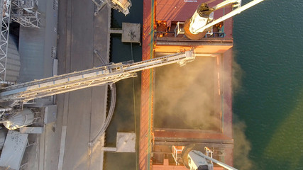 Aerial view of big grain elevators on the sea. Loading of grain on a ship. Port. Cargo ship