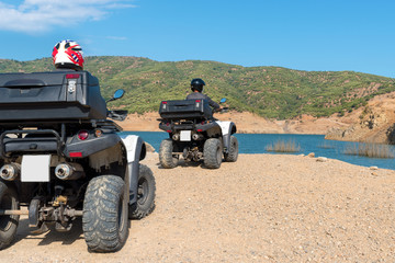 Fototapeta premium Two mans in protective helmets is driving ATV on off-road.