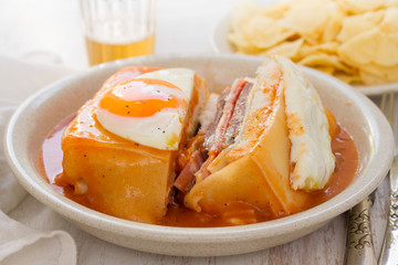 traditional portuguese sandwich with sauce francesinha on dish