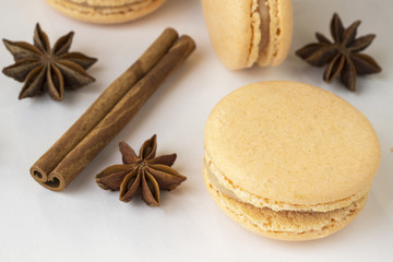 Sweet macarons, spices anise and cinnamon sticks on white background