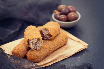 meat croquettes on paper on wooden background