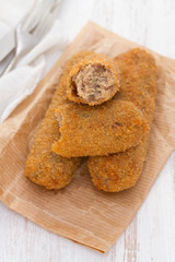 meat croquettes on paper on wooden background