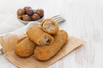 meat croquettes on paper on wooden background