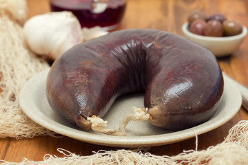 smoked blood sausage on white dish on wooden background