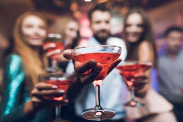 Young people have fun in a nightclub. They drink cocktails and have fun.