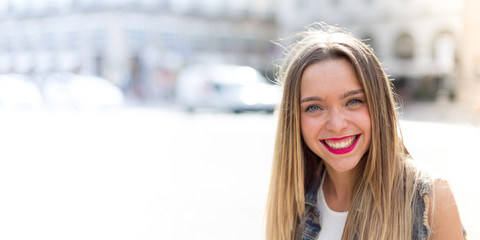 Beautiful blonde teenager model outdoor in the city. Horizontal wide banner with blurred copy space on the left