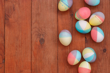 brown wood plank background with painted Easter eggs
