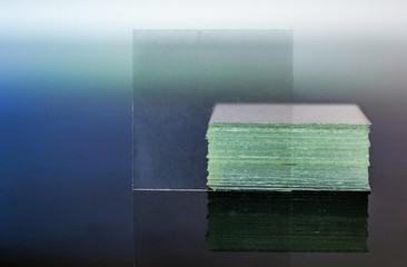 Microscope coverslip glass reflecting on glass table closeup