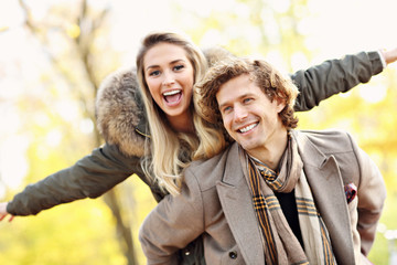 Happy couple walking in the forest during autumn