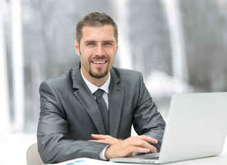 closeup.smiling businessman working with laptop