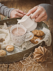 coupnum up of hand pouring milk into cocoa