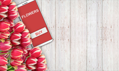 tło kupna i sprzedaży kwiatów, czerwone tulipany na stole i telefon. - 181538938